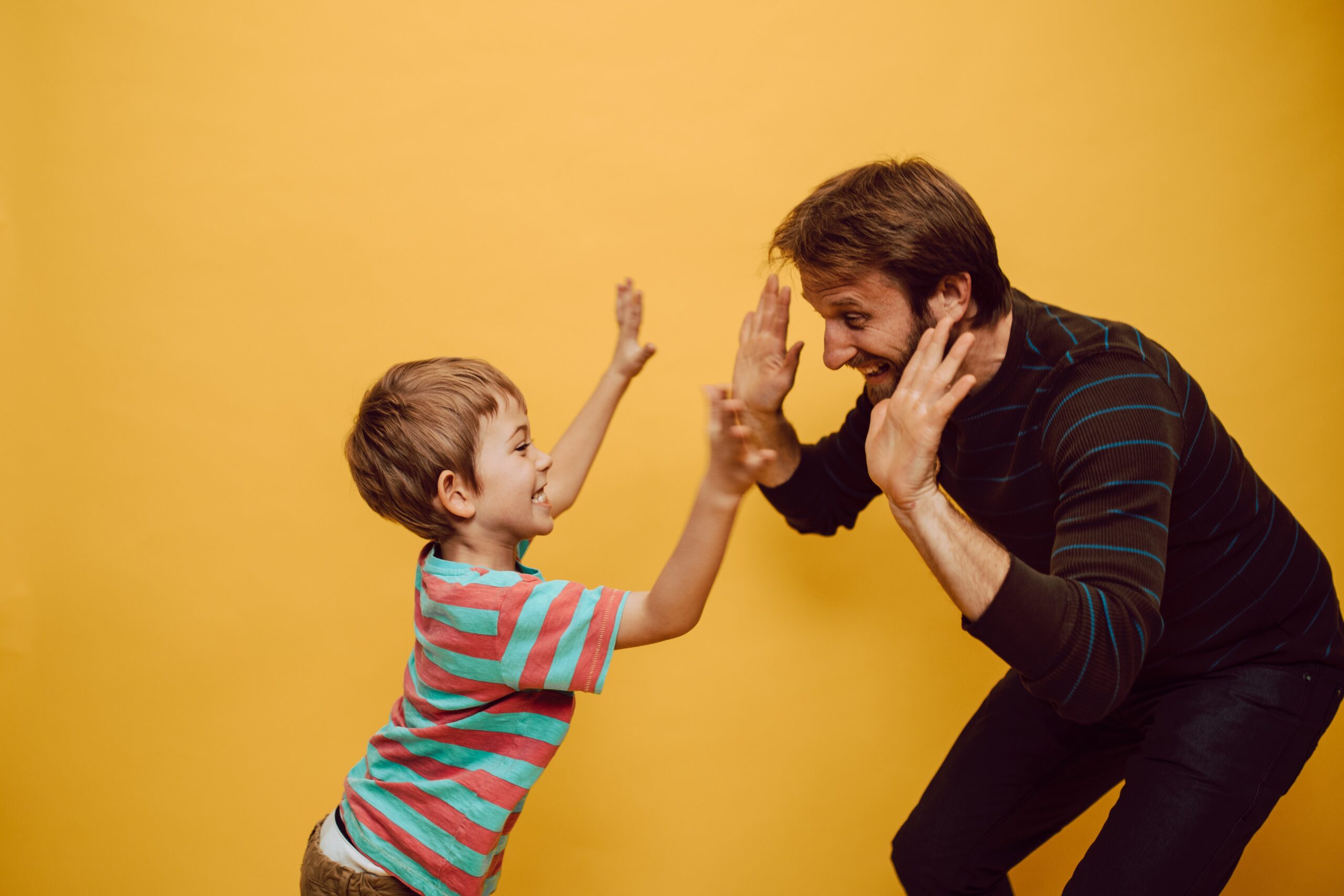 Father and child son high fiving